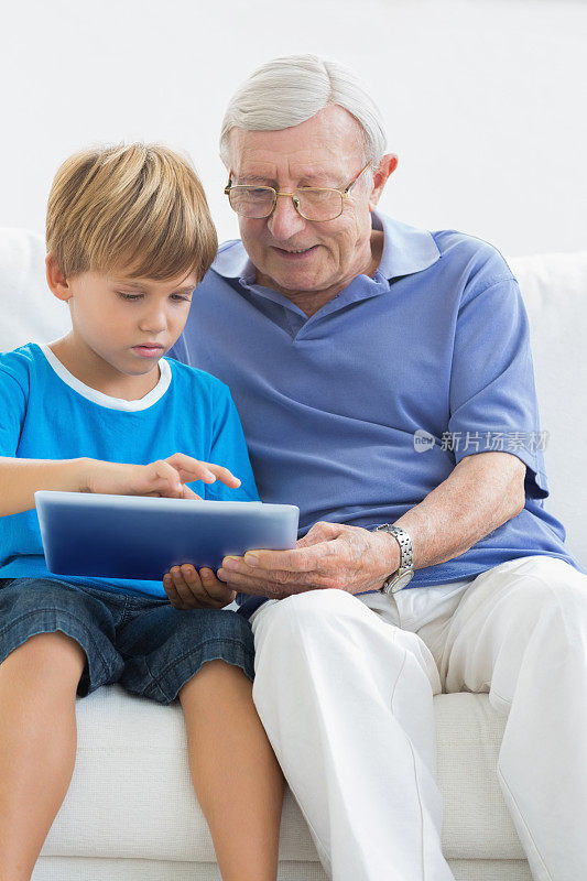 爷爷和孙子一起触摸着平板电脑