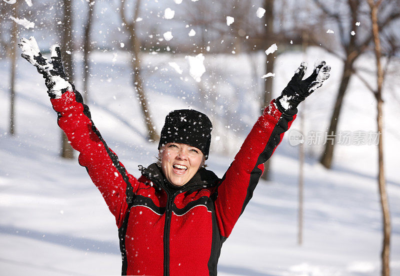 成熟的女人在雪地里玩。