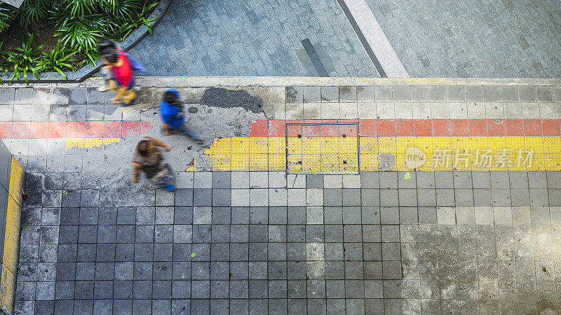 鸟瞰图和俯视图与人行走在商业区的行人和红色和黄色街区的人行道