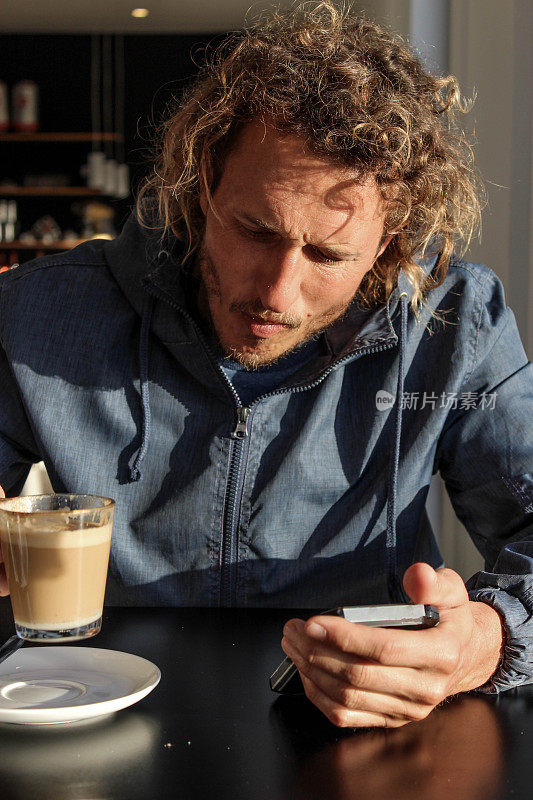在咖啡馆里用手机的男人