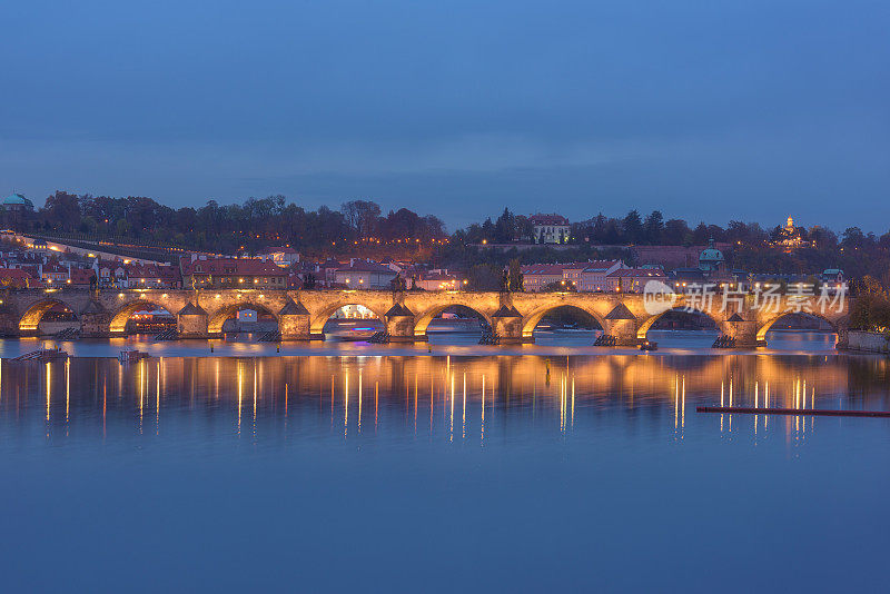 布拉格，灯火通明的查尔斯桥(卡尔鲁夫最)与水中倒影，夜景优美的城市景观
