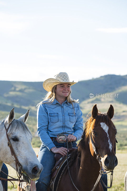 在犹他州山上骑着马的女牛仔
