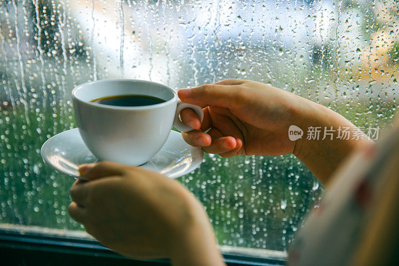 下雨天靠窗喝咖啡的女人