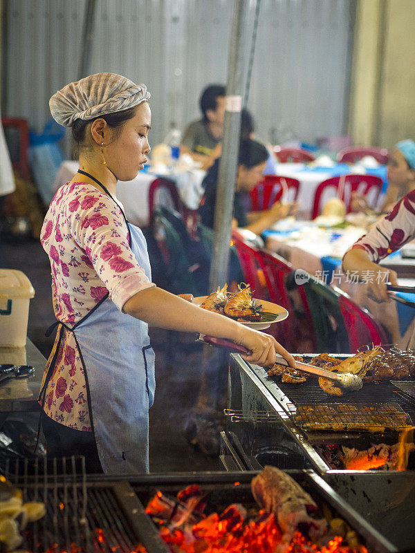 越南胡志明市，一名妇女正在烹煮新鲜的海鲜