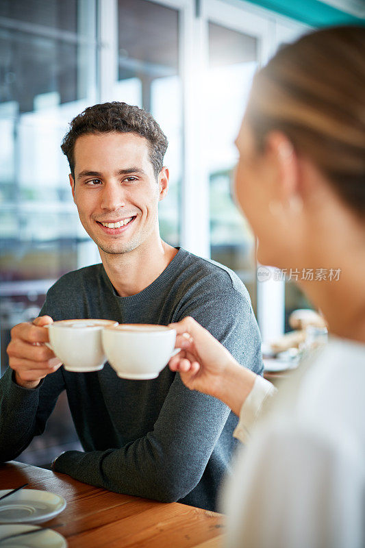 年轻夫妇在咖啡店约会分享微笑