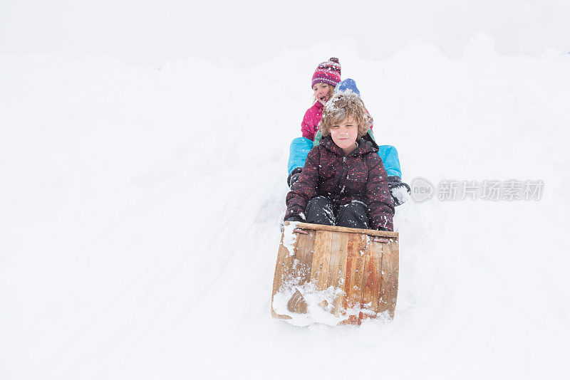 孩子们在暴风雪中快乐地玩雪橇