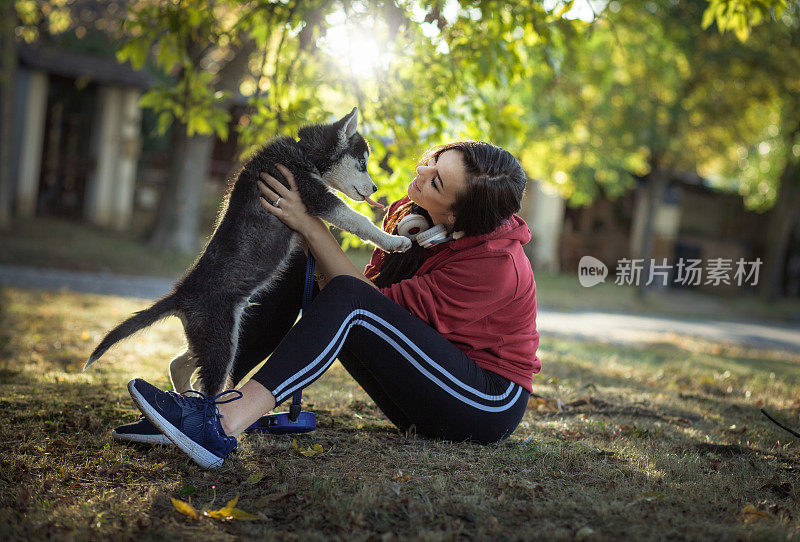 一个年轻女人带着狗在秋天的大自然中散步