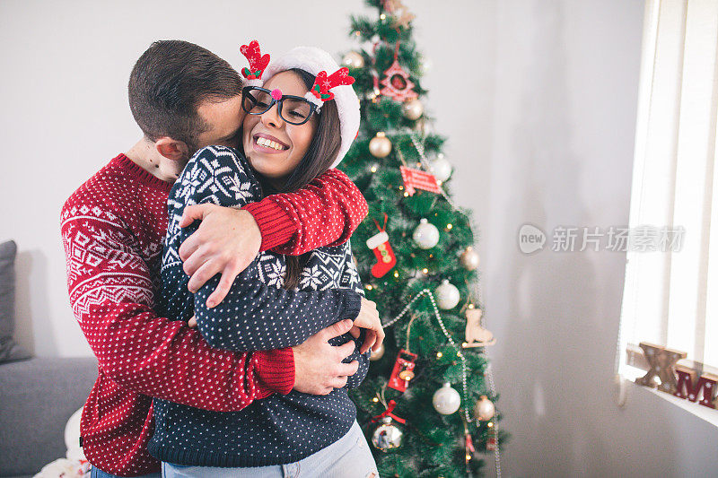 快乐的夫妇装饰圣诞树。