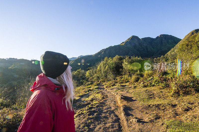 年轻女子在山间小径徒步旅行