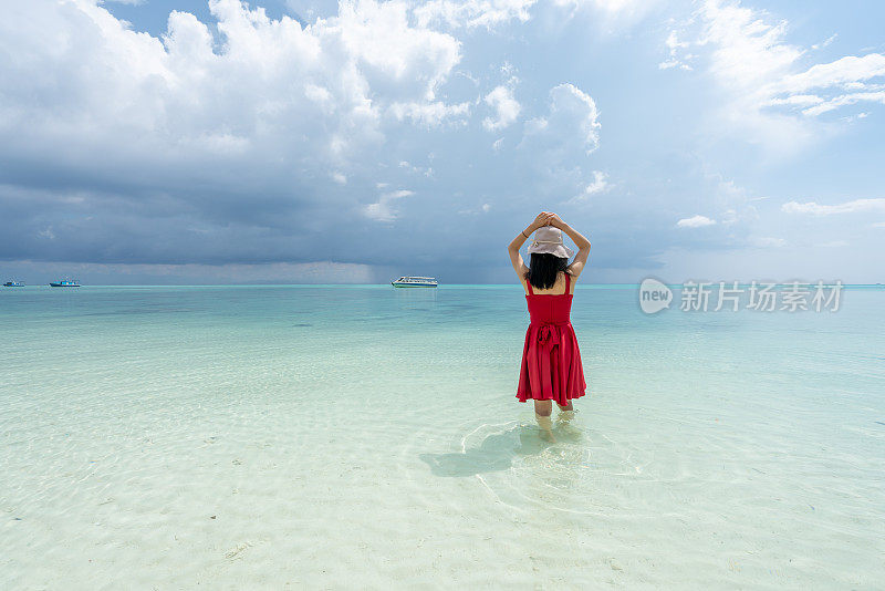 一个女孩在海滩上穿着红色的衣服