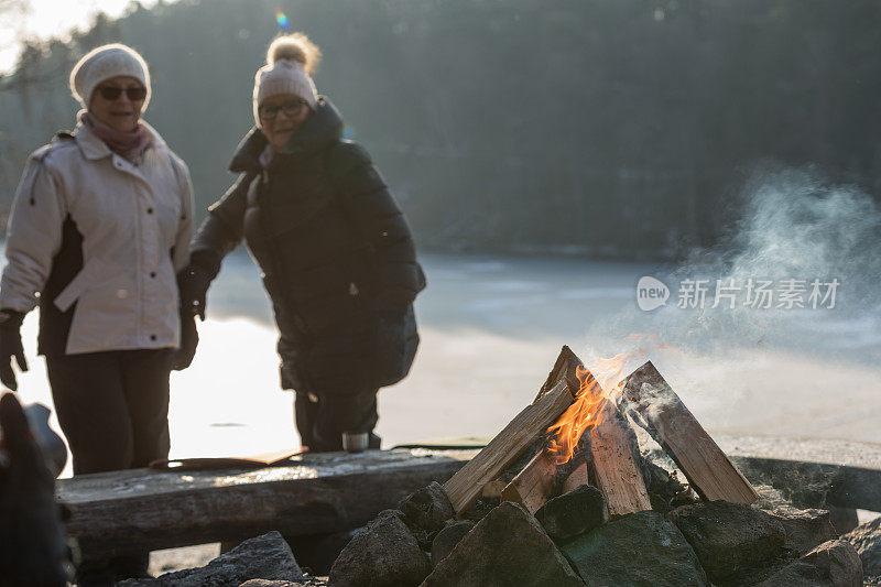 年长的女士们站在篝火旁