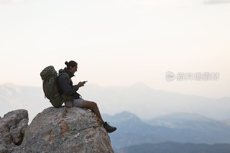 登山者在山顶使用智能手机