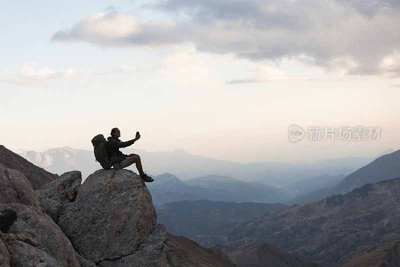 登山者在山顶使用智能手机