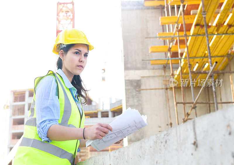 女建筑师在建筑工地看蓝图