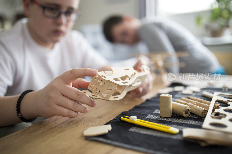 兄弟们正在为学校项目制作木制模型飞机