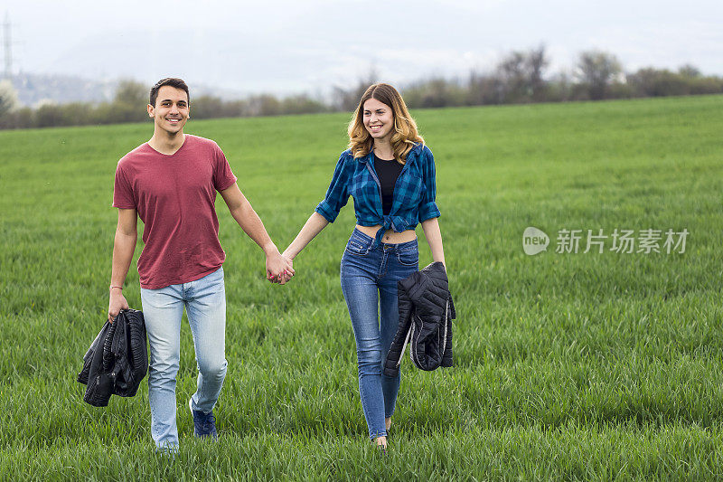 一对情侣在田野里散步，玩得开心