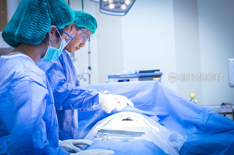 身着制服的外科医生在心脏外科诊所给病人做手术。