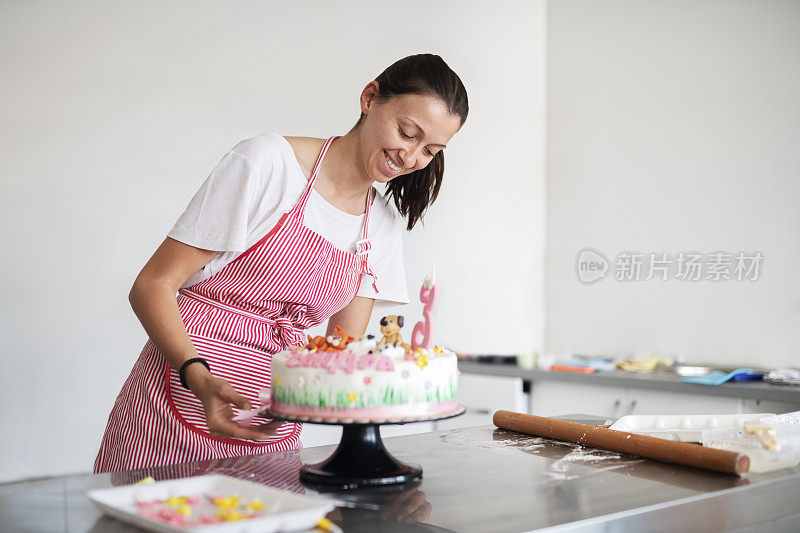 一位年轻的糕点师正在做蛋糕。