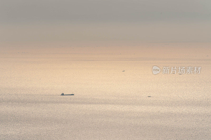 一艘船在早晨的阳光下航行在波光粼粼的海面上