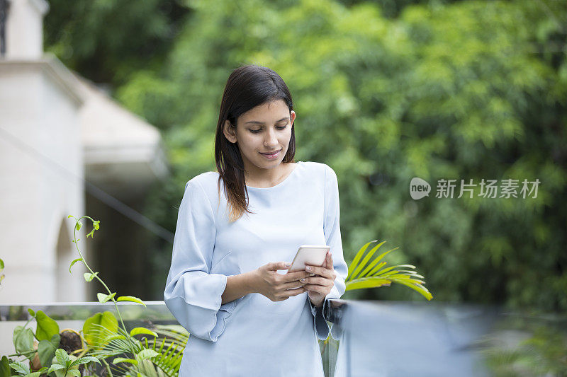 女人的手机在阳台库存照片