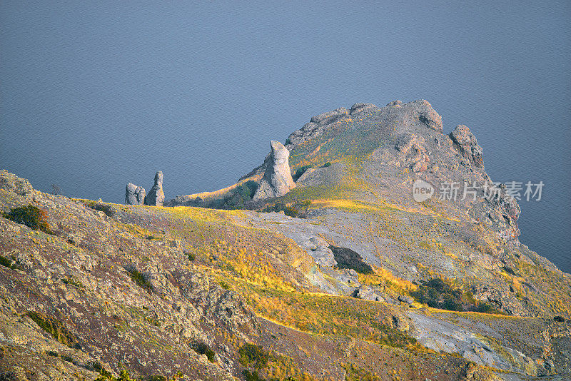 岩石顶部和干燥的树，卡拉达火山，克里米亚海岸，阴沉沉的天空，雾，白色的天空。