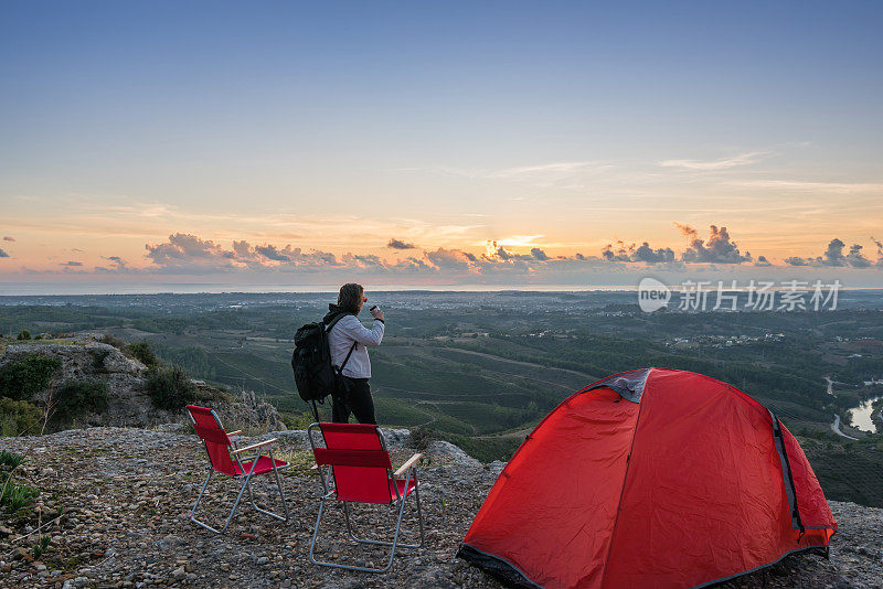 年轻的背包客站在山顶欣赏风景