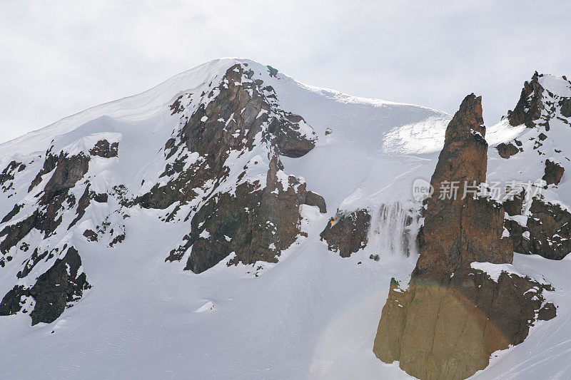 偏远地区的滑雪者从积雪的山脊上下来