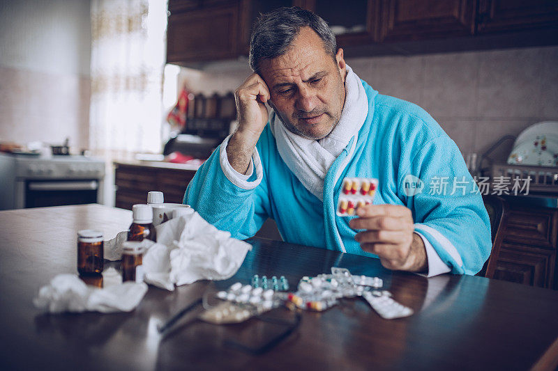 一个生病的老人坐在餐桌旁