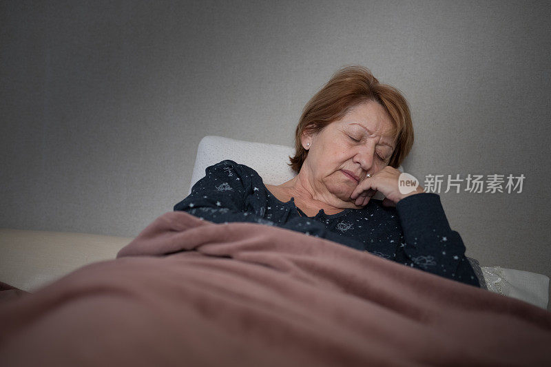 病弱的成熟妇女65-70岁，发烧躺在床上隔离