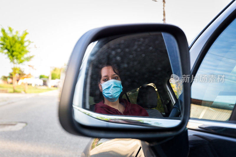 女司机戴着防护面罩反射在镜子里