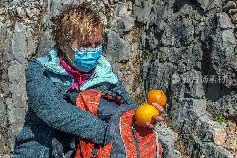 妇女戴着面具在徒步旅行期间独自在阿尔卑斯山南部，斯洛文尼亚，欧洲休息