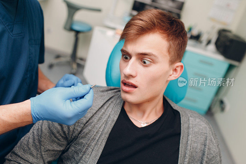 牙医。牙科医生向牙科诊所的病人展示植牙。