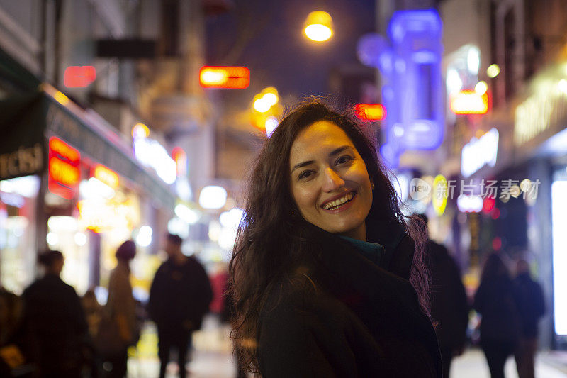 晚上在城市道路上快乐的女人的肖像