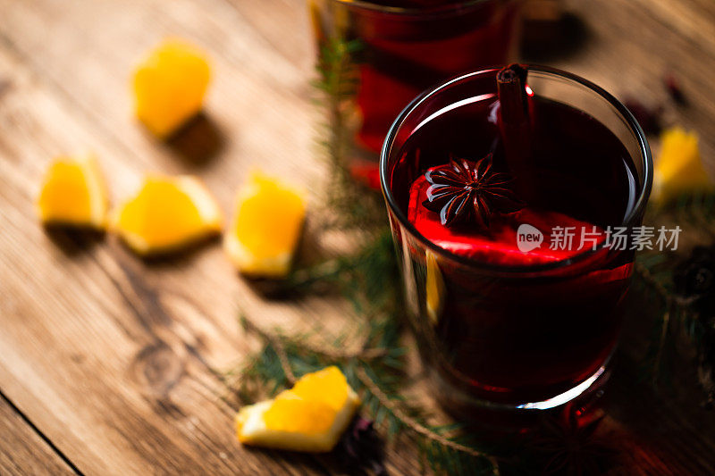 用透明玻璃杯盛着圣诞热葡萄酒，并撒上香料和柠檬片