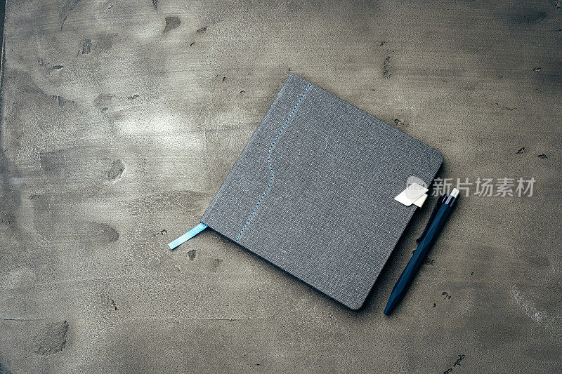 深灰色背景的男人日记和钢笔