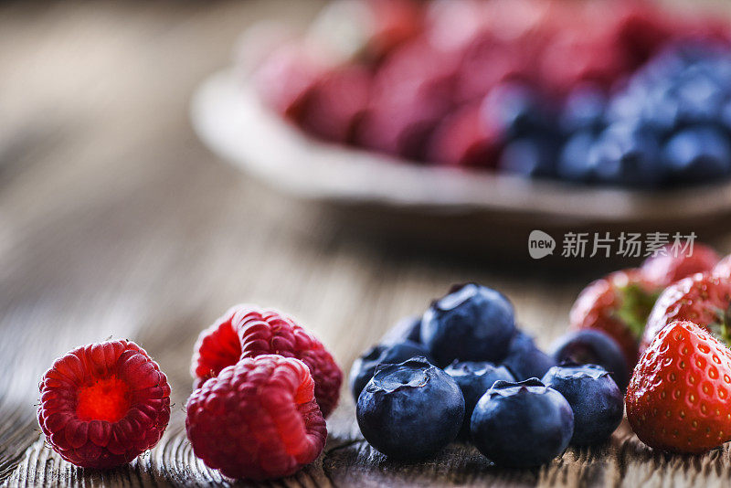 木碗里的林果。蓝莓、树莓、草莓