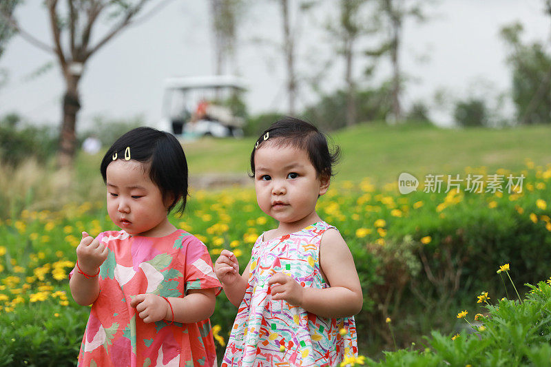 两个中国女孩在公园里美丽的小路上玩耍