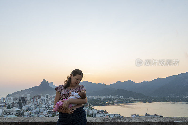 母亲在里约热内卢的天际线上给女儿哺乳