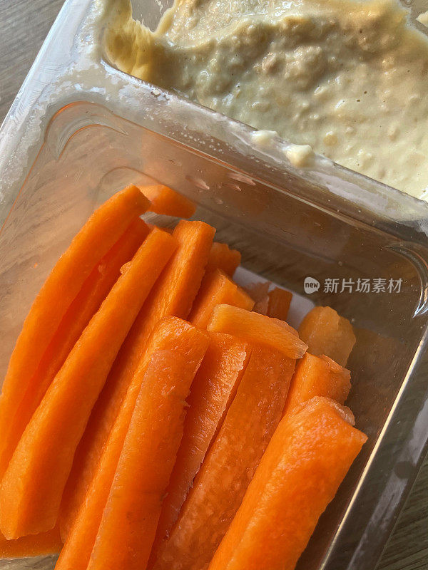 生胡萝卜棒和在一次性塑料容器里蘸酱的特写图像，健康的零食，高架图