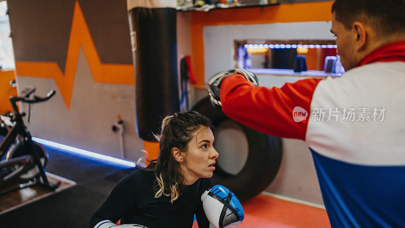女拳手和她的教练在健身房练习