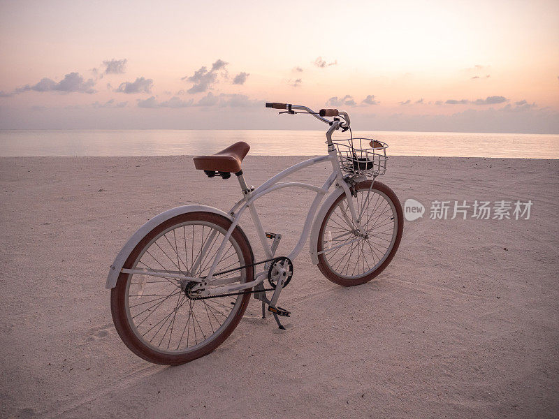 日落时在海滩上骑自行车