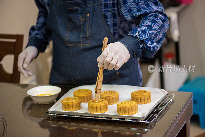 面包师在烤盘上用鸡蛋面团画自制月饼