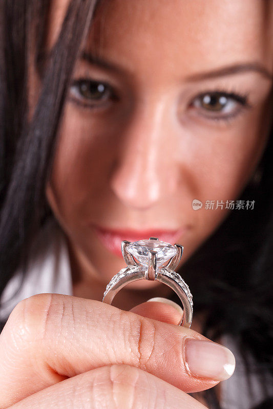 美丽的年轻女子展示钻石订婚戒指