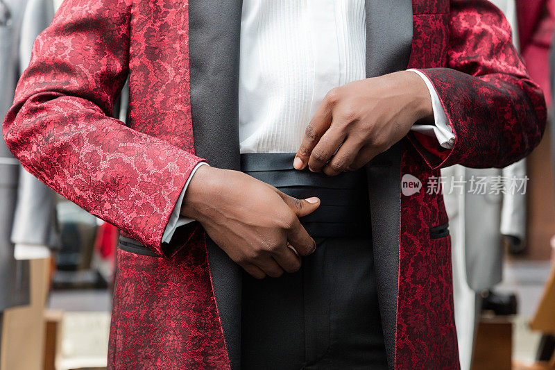 裁缝店黑色男士穿红色燕尾服的手的细节