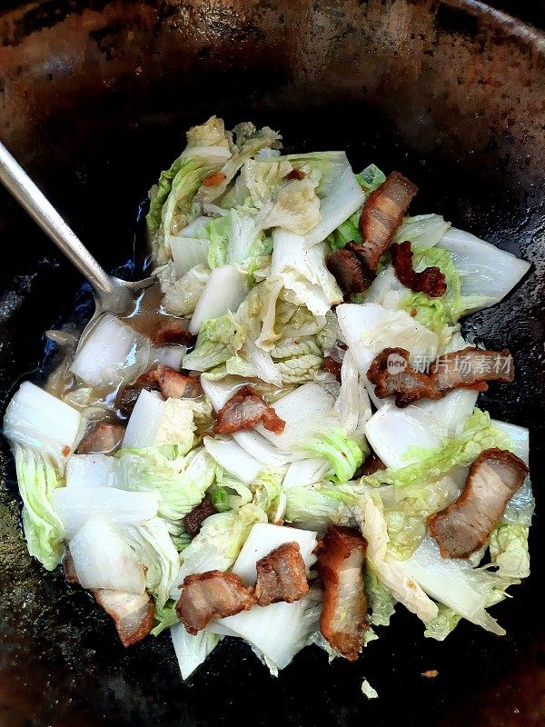 用平底锅煸炒五花肉白菜。