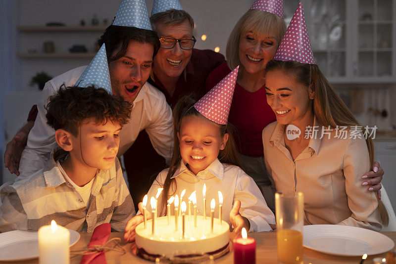 可爱的小女孩收到美味的生日蛋糕和点燃的蜡烛生日，庆祝节日的大家庭