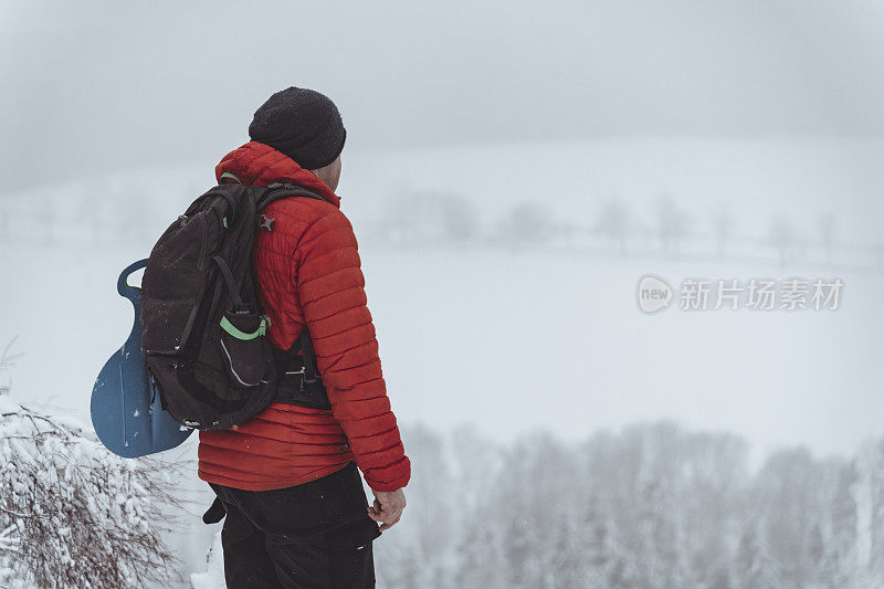 游客眺望着白雪覆盖的山谷