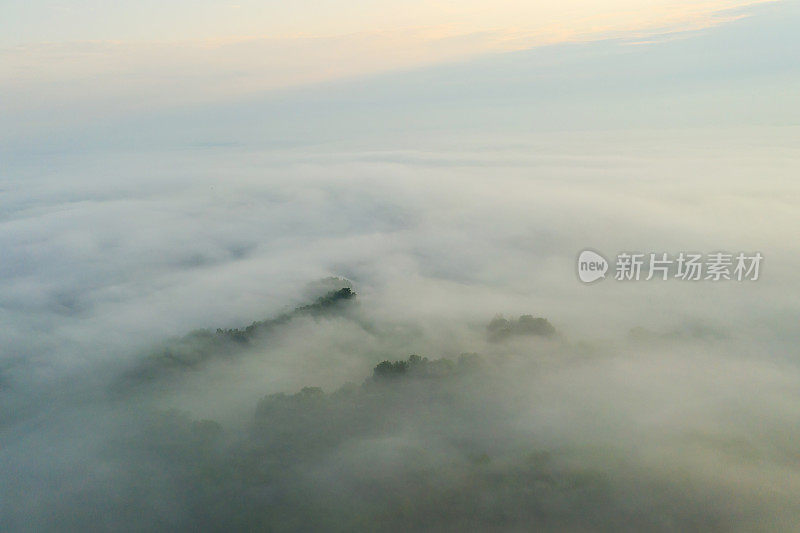 雾蒙蒙的黎明。草甸鸟瞰图。地球上方的云层。春天的大自然。夏天自然背景。无人机摄影。地球上空飞行。可持续性。大气神秘的景观