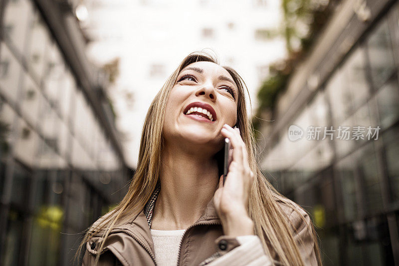 自信的年轻职业女商人正在用智能手机打电话