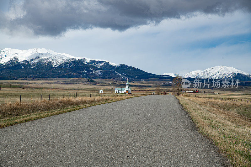 蒙大拿州的乡村公路朝着雪山驶去